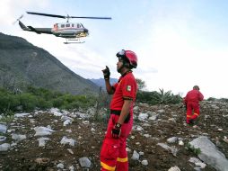 Autoridades federales y de protección civil observan el sitio donde cayó la aeronave donde viajaba Jenni Rivera. EFE  /