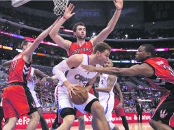 Imparable. Blake Griffin (de blanco) captura un rebote ante la marca de tres oponentes. AP  /