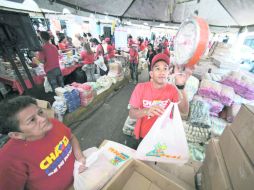 Subsidio estatal. Un trabajador pesa alimentos en un mercado. Las despensas son para las personas con bajos recursos. AP  /