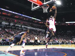 Facilito. LeBron James se prepara para anotar, ante el intento de marca de dos defensas de los Bobcats. REUTERS  /