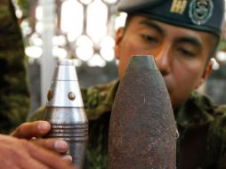 Un soldado examina artillería pesada entregada en el programa de desarme voluntario. AP  /
