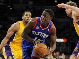 Jrue Holiday, al centro, corre entre Darius Morris (i) y Pau Gasol (d) de los Lakers. AP  /
