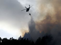 Al menos cuatro mil galones de agua han sido lanzados desde el aire por tres helicópteros militares. AP /