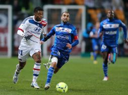 Mounir Obbadi del Troyes (i), corre frente al mediocampista del Lyon Bastos. AFP /