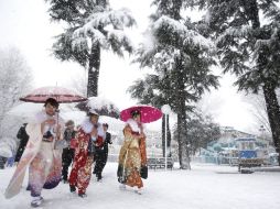 Jovencitas caminan en Tokio bajo la nieve en camino a celebrar su mayoría de edad. EFE /