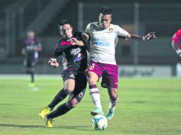 Disputa. Marcelo Alatorre (derecha), de Estudiantes, trata de avanzar ante la marca de un jugador de los Tiburones Rojos. EL INFORMADOR /