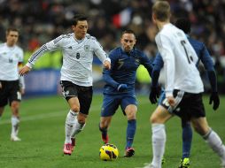 Özil trata de quitarse la marca de Ribery durante el partido celebrado en Saint Dennis. EFE /