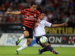 Acción del partido entre Atlas y Atlante donde Omar Bravo trata de controlar el balón ante un defensivo de los Potros. MEXSPORT /
