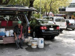 Las personas que se dedican al estacionamiento y cuidado de coches, son sólo una de las caras del desorden que vive la Zona Rosa. ARCHIVO /