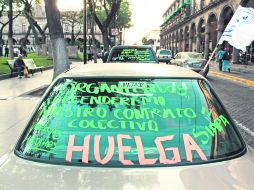 Cerca de 25 autos particulares pintados con mensajes de protesta se dieron cita en el Centro Histórico. EL INFORMADOR /