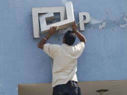 Un trabajador durante el retiro de las siglas en el edificio de la extinta Procuraduría General de Justicia del Estado.  /
