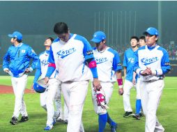 Caras largas. Los jugadores de Corea del Sur se retiran del diamante, tristes luego de no lograr su boleto a la segunda ronda. EFE /