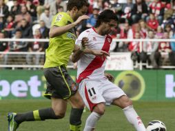 El delantero del Rayo Vallecano Alejandro Damián Domínguez controla el balón ante el delantero del Espanyol Christian Ricardo. EFE /