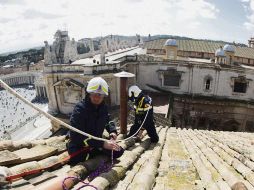 Últimos toques. Bomberos de El Vaticano realizan reparaciones menores en la chimenea de la Capilla Sixtina, previo al Cónclave. AFP /