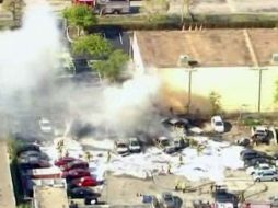 Después de que bomberos apagaron el fuego, se mostraron imágenes de varios vehículos calcinados en un estacionamiento. AP /
