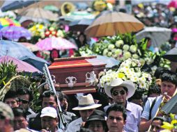 Marcha fúnebre. En solidaridad con las víctimas, el poblado realizó un funeral masivo. AFP /