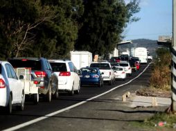 La fila de autos se extiende ya varios kilómetros, por lo que se recomienda a los turistas que regresan: mucha paciencia. ARCHIVO /