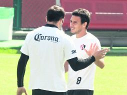 Matías Vuoso y Lucas Ayala platican durante el entrenamiento rojinegro en las instalaciones de Colomos. MEXSPORT /