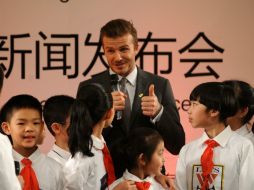 Beckham convive con pequeños en China, donde deja entrever podría jugar algún día. AFP /