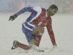 El campo se cubrió de nieve y los jugadores costarricenses no lograron que el silbante suspendiera el cotejo. EFE /