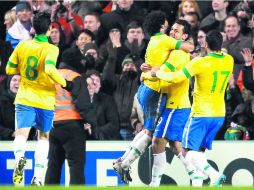 Festejo. Los brasileños felicitan a Fred (9), que los salvó de otra derrota en Londres. EFE /