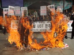 Activistas surcoreanos queman dos retratos de los exlíderes norcoreanos Kim Il-Sung y Kim Jong-Il durante una manifestación. EFE /
