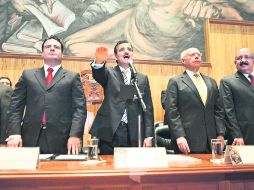 El nuevo rector general cumple con el protocolo, flanqueado por el gobernador Sandoval (izquierda) y el rector de la UNAM, José Narro. EL INFORMADOR /