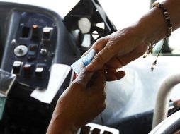 En la imagen, un chofer cobra a un usuario.  /