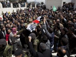 Varios policías portan el cuerpo del prisionero palestino muerto por cáncer en un hospital israelí, Maysara Abu Hamdiye. EFE /