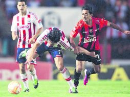 Abajo. Rafael Márquez Lugo, quien firmó un doblete, es jalado por el defensa de Jaguares, David Toledo, en una jugada del partido MEXSPORT /