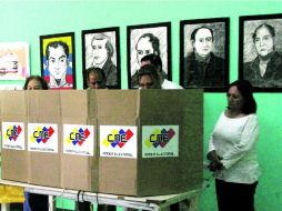 Efectivos militares del Plan República junto con miembros electorales revisan las máquinas de votación . NTX /