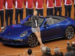 Así posó la bella tenista junto al Porsche que le fue otorgado al ganar el torneo. AFP /