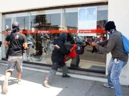 Un grupo de jóvenes ataca un banco en medio de las marchas por el Día del Trabajo. NTX /