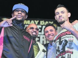 Floyd Mayweather Jr. y Robert Guerrero posan delante de Leonard Ellerbe, agente de Mayweather y el promotor Oscar De La Hoya. AP /