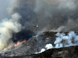 Ocho helicópteros, seis avionetas y alrededor de mil bomberos combaten un fuego que hasta ahora ha destruido 15 edificios. EFE /