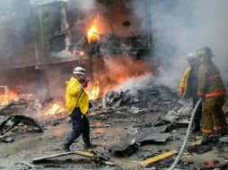 Socorristas de PC y del Cuerpo de Bomberos de Valencia luchan contra las llamas, en tanto que la policía acordonó el área. EFE /