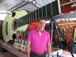 El artesano Luis Colón Ortiz posa al lado del instrumento que pesa mil 600 kilogramos. EFE /