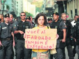 Protesta contra los gastos por el mundial. ''Usted ahí uniformado también es explotado'', dice el cartel que porta una manifestante. EFE /