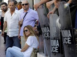 Varios empleados de la radiotelevisión pública griega ERT permanecen sentados en las escaleras del Consejo de Estado. EFE /