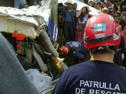 Bomberos voluntarios ayudan en la labor de rescate de los cuerpos de la avioneta siniestrada. AFP /