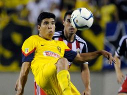 Luis Mendoza, del América, intenta quitarse la marca de Patrico Araujo. AP /