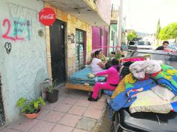 Vecinos de la calle Plata, entre Arroyo y Orquídeas, custodian sus pertenencias luego de que fueran desalojados. EL INFORMADOR /