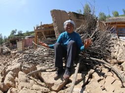 Un habitante del poblado de Hetuo llora ante los restos de lo que fuera su hogar. AFP /