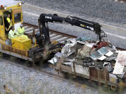 Los trabajadores retiran lo que queda del convoy accidentado. EFE /