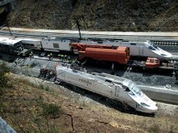 Un tren Alvia pasa junto a los restos del ferrocarril que descarriló en las inmediaciones de Santiago de Compostela. EFE /