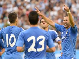 Benzema (der) celebra con sus compañeros el gol que anotó al PSG. AFP /