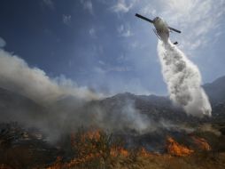 Un helicóptero arroja agua a una de las zonas afectadas por el incendio. ARCHIVO /