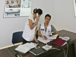 Funcionarios de la Cruz Roja trabajan para la eventual reunión de familias en sus instalaciones. AP /