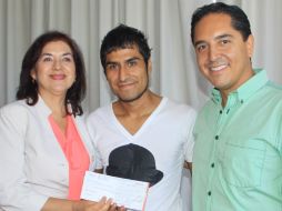 Humberto Fierros Ramírez (c) muestra el cheque recibido. ESPECIAL /