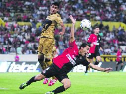 Omar Bravo, quien fue el autor del único tanto rojinegro, cae al césped, después de que un zaguero de Pumas le comete falta. EFE /